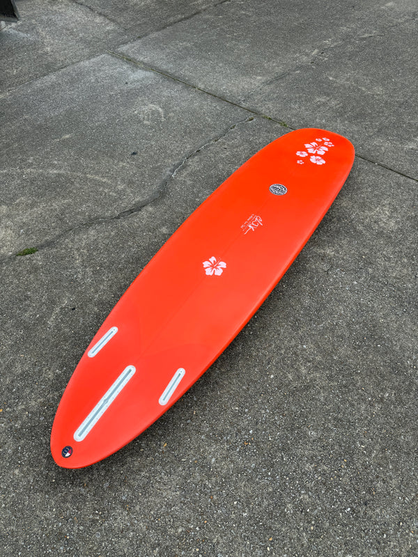 orange and white mid length surfboard with floral print