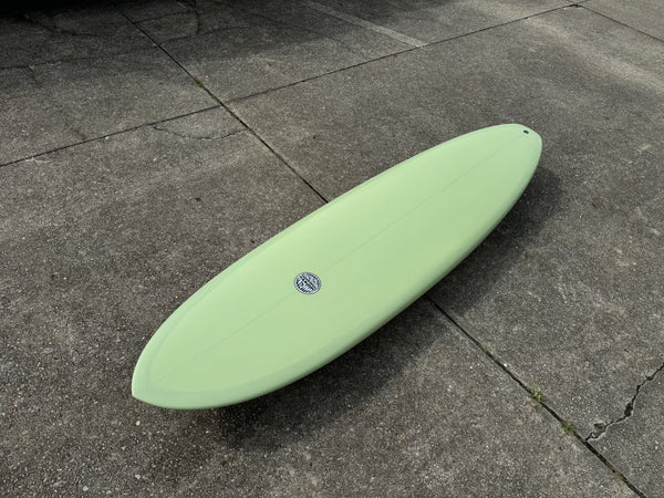 green mid length surfboard