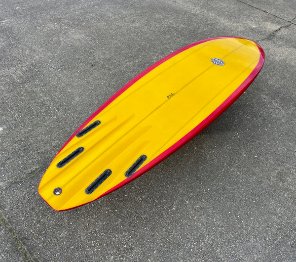 red and yellow mid length quad fin surfboard