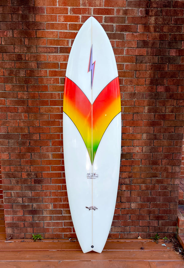 white and multi colored mid length swallow tail surfboard