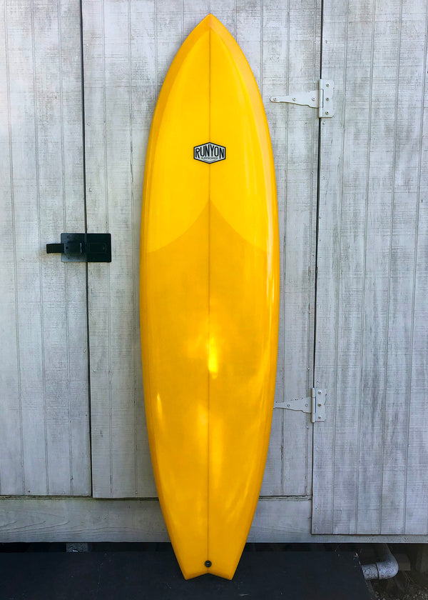 yellow mid length swallow tail surfboard