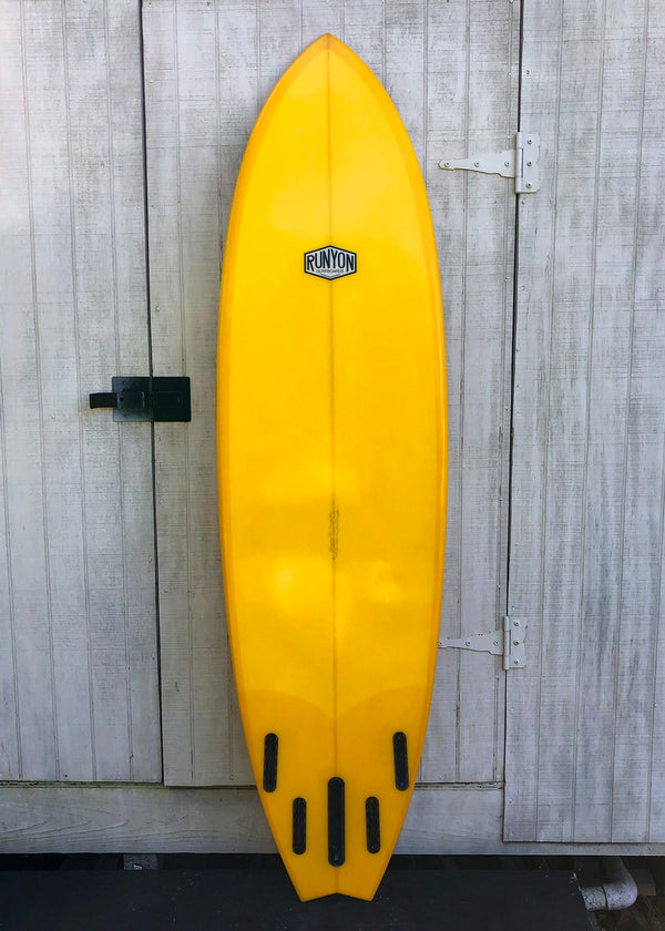 yellow mid length swallow tail surfboard