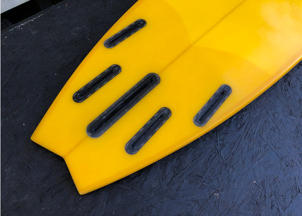 yellow mid length swallow tail surfboard
