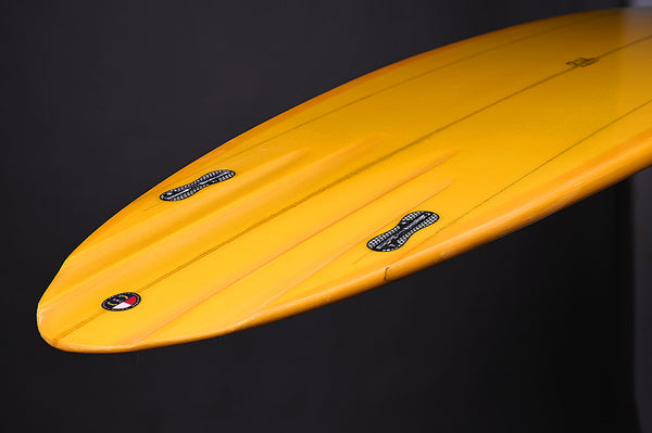 Orange Surfboard upside down, on a back background. 2 Fin Setup, with FCS Fin Boxes.