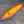 Surboard laying on cement. Blue edges, Sunset red to yellow color in the center. Runyon Logo, with skull towards the tail 