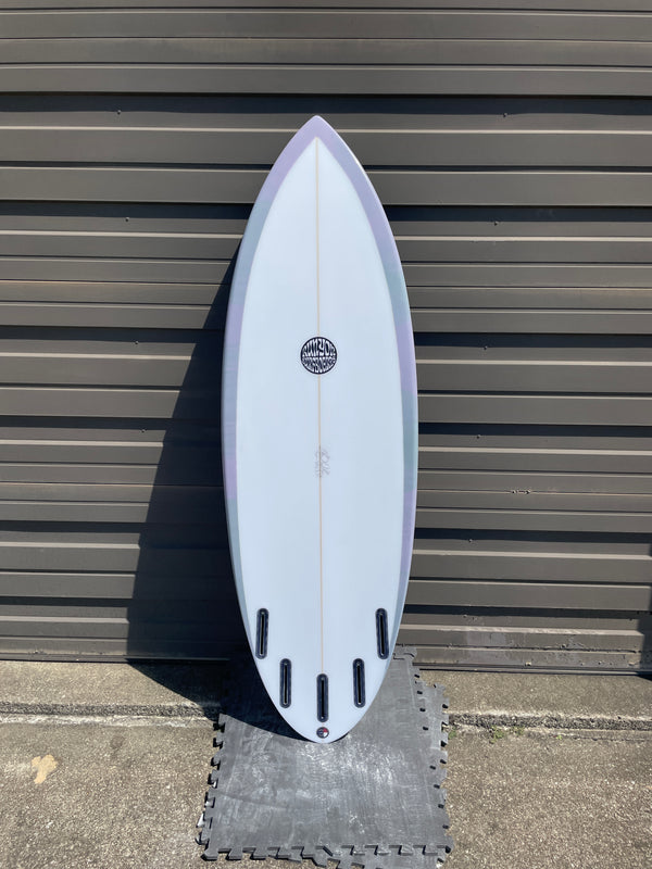 Surfboard standing against metal wall. Pastel pink and purple rim, white center. 4 +1  Future fin boxes, 