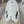 White asymmetric surfboard laying on stand in workshop. 3 Fin boxes on right side of fish tail, 2 fin boxes on the left. 