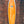 King Fish Surfboard, Orange and White Swirled design, with white frame. Leaning against a brick wall. 